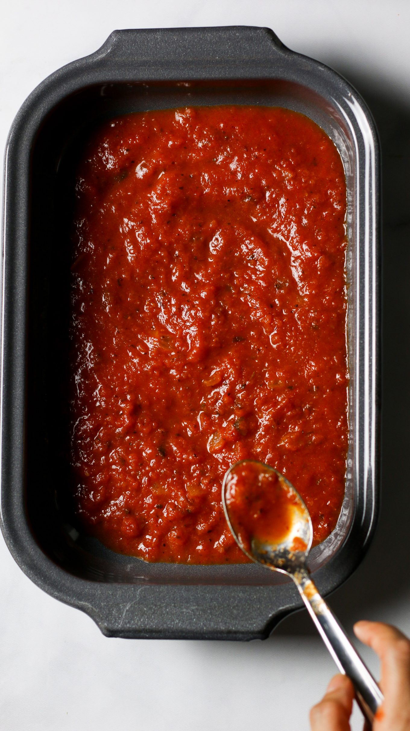Platón para horno gris con salsa marinaera de tomate