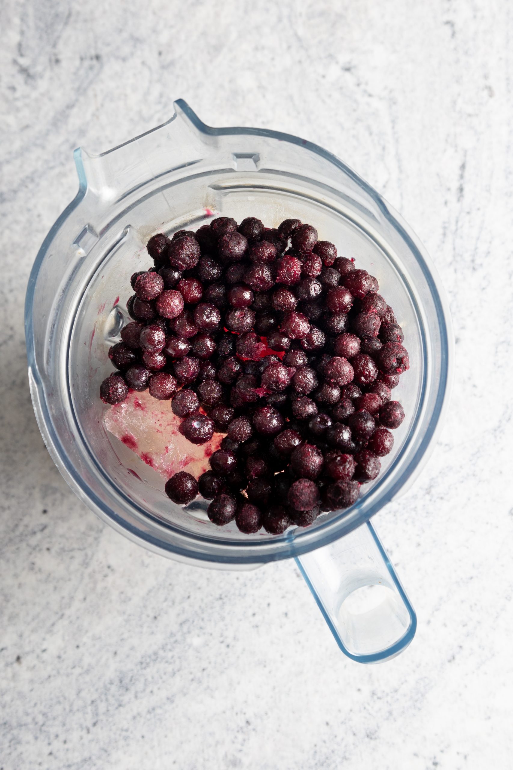 moras azules y hielo de vino blanco en vaso de licuadora