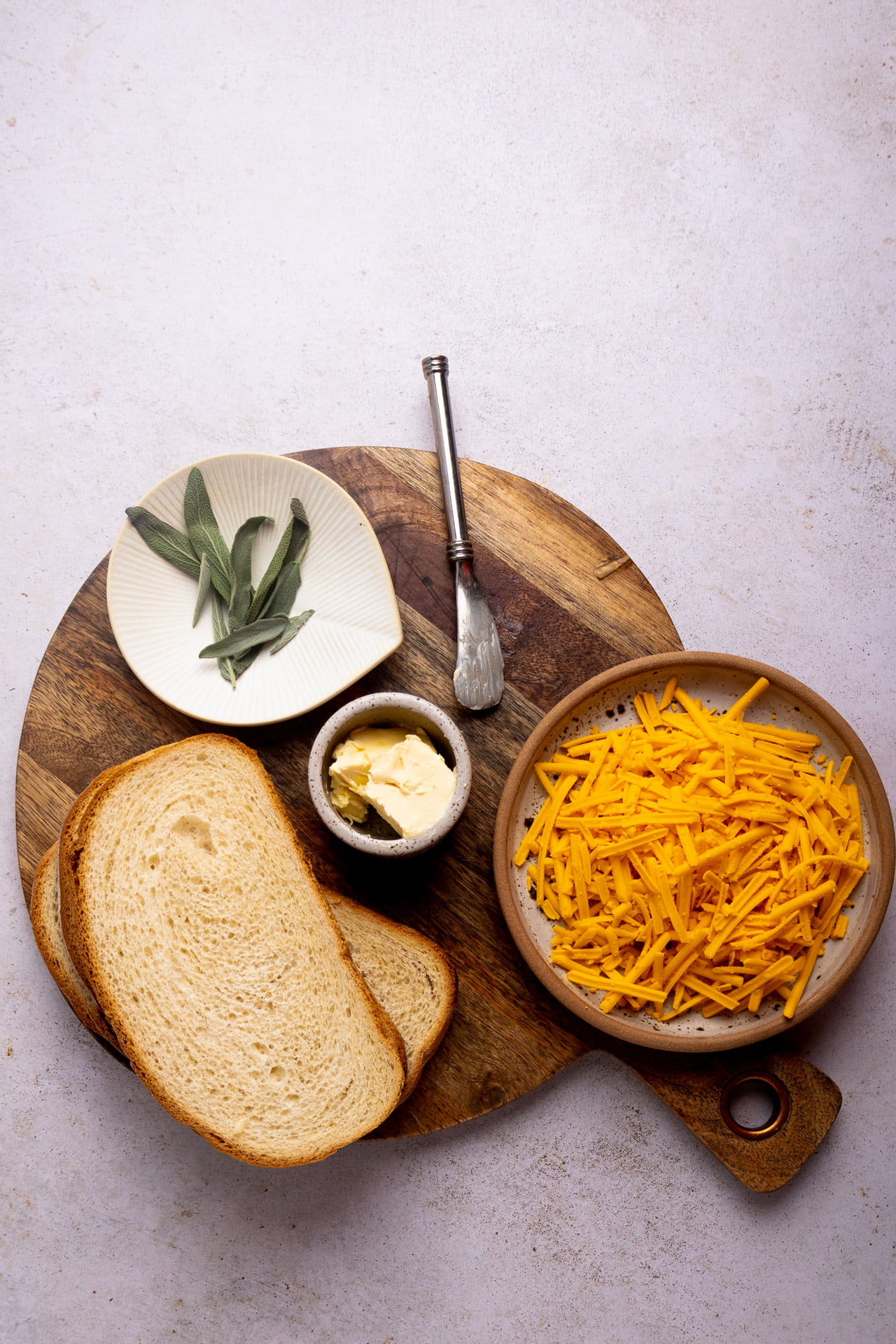 Pan, queso, mantequilla y hojas de salvia.