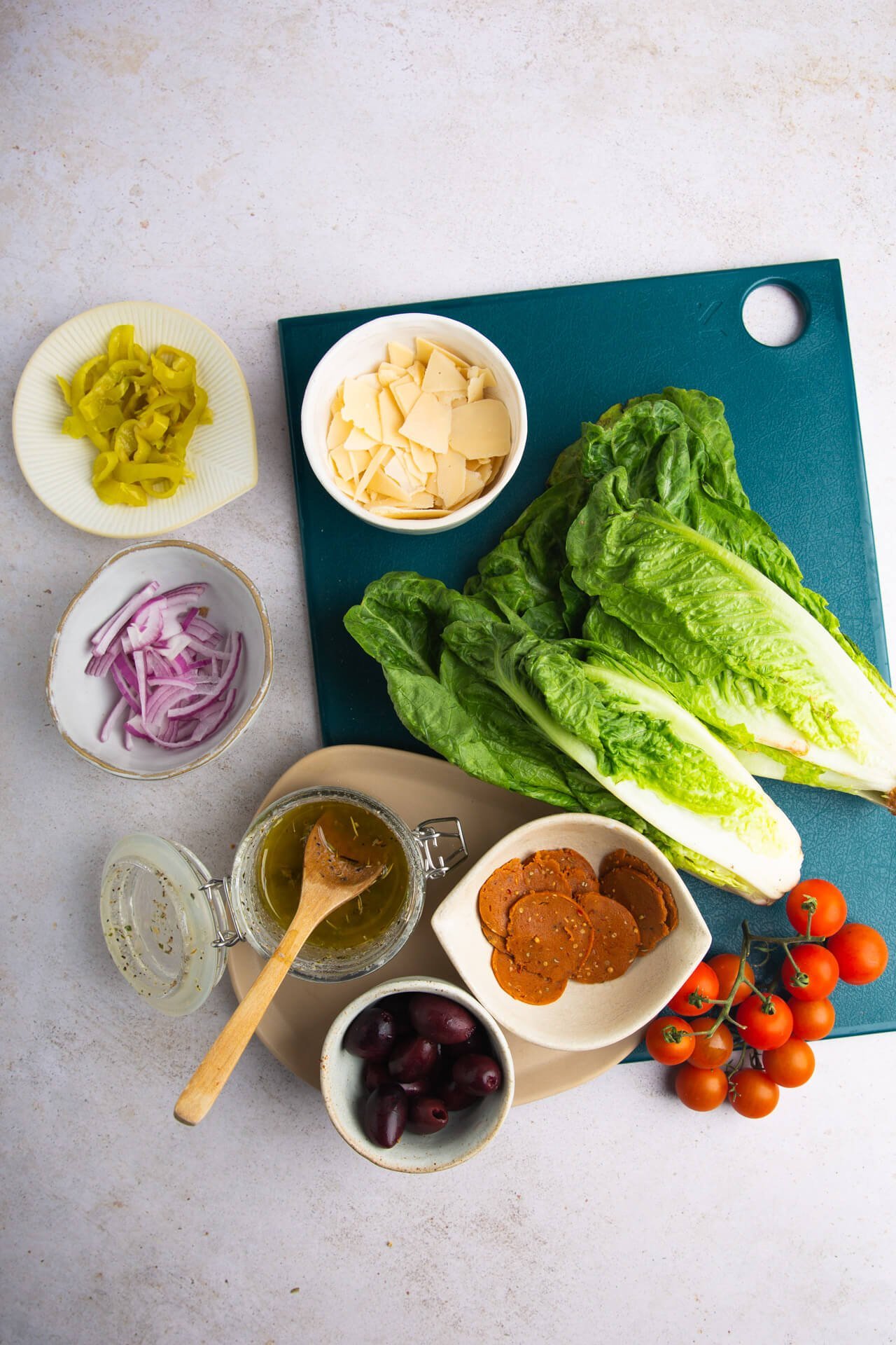 Lechugas romanas, tomates cherry, queso peperoni, aceitunas y aderezo para ensalada italiana.