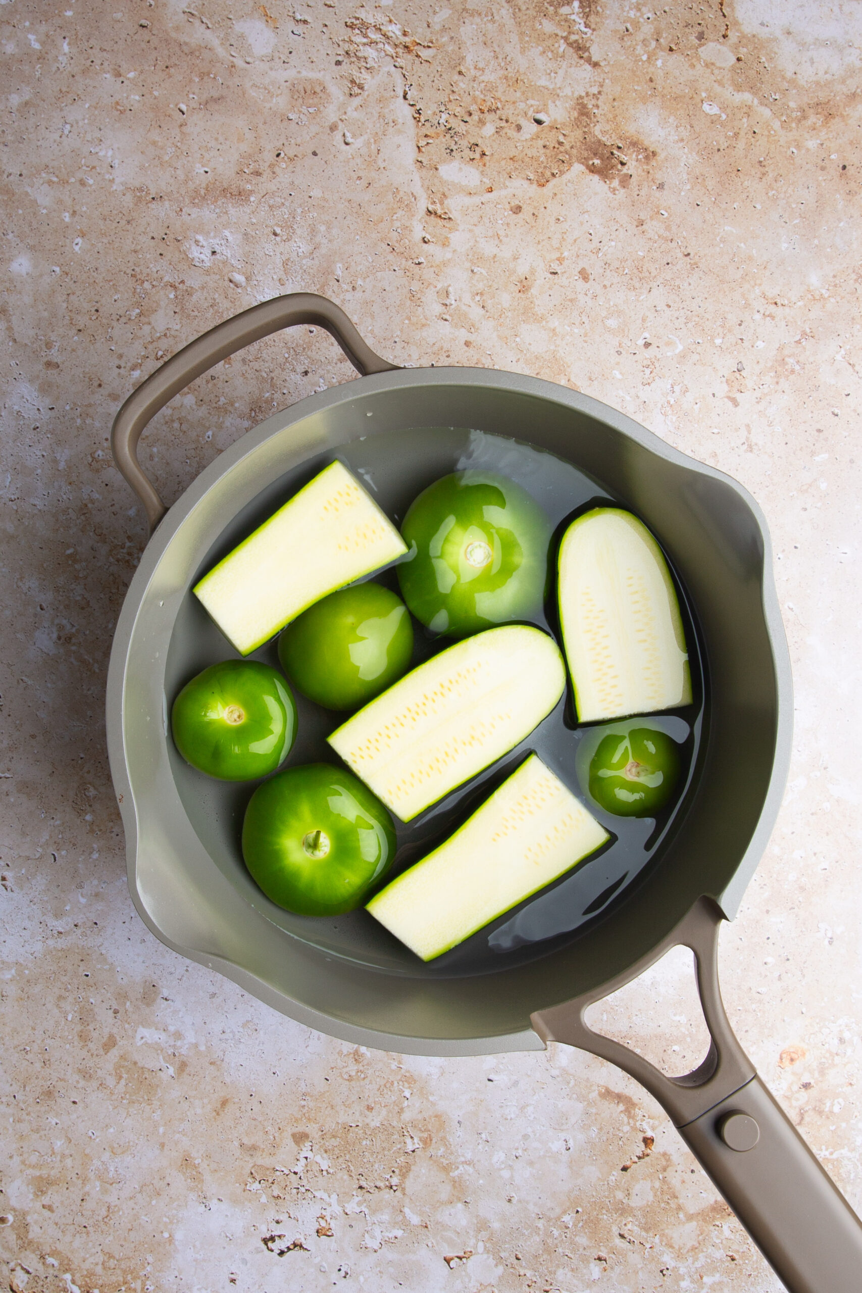 tomatillos y calabacitas en un aolla con agua