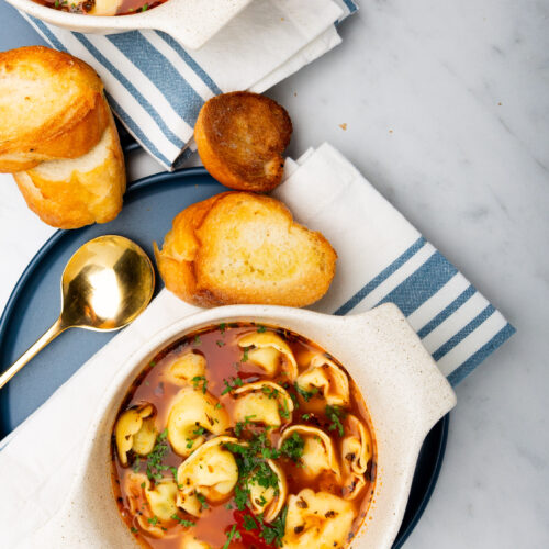 Dos tazones de sopa saludable con pan en una mesa.