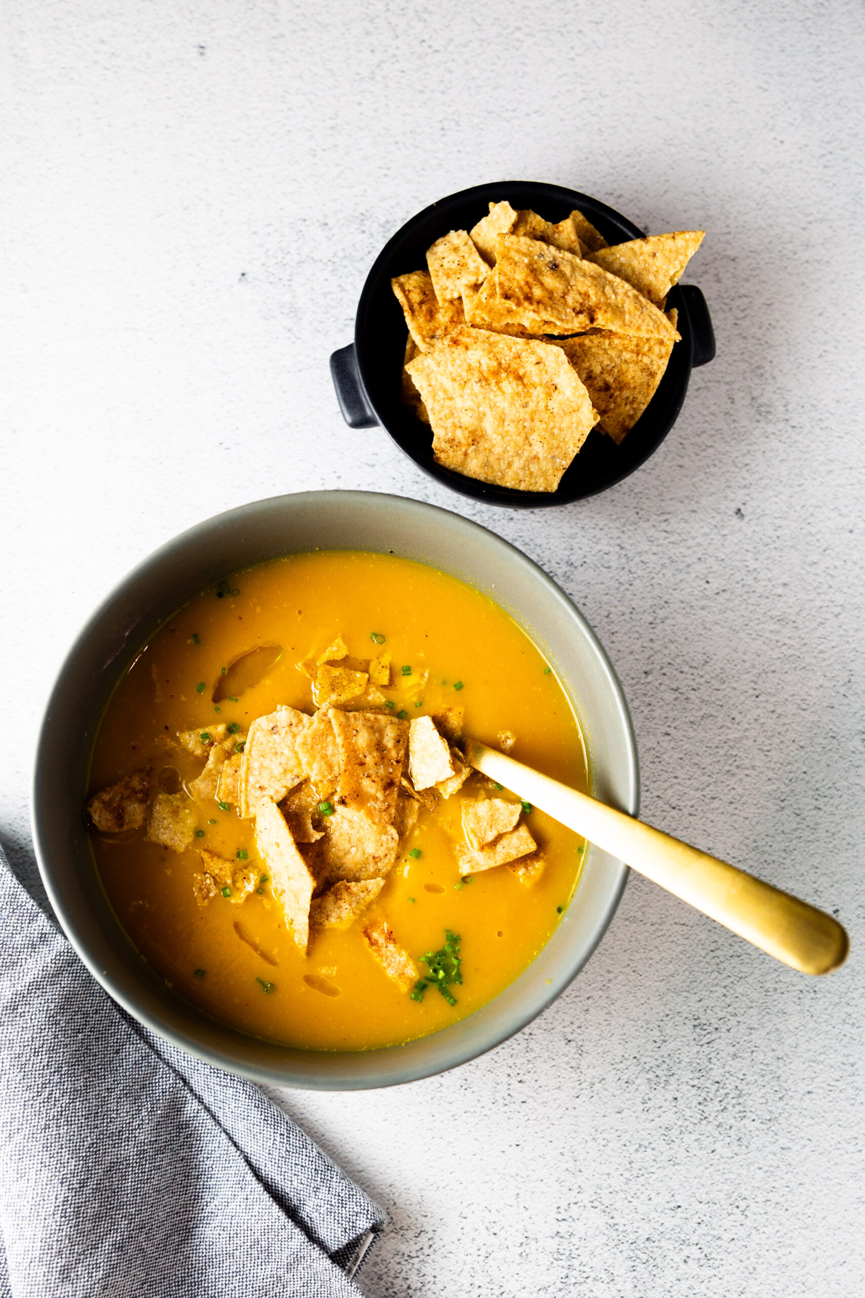 Una receta fácil de sopa de calabaza Butternut servida con chips de tortilla crujientes.