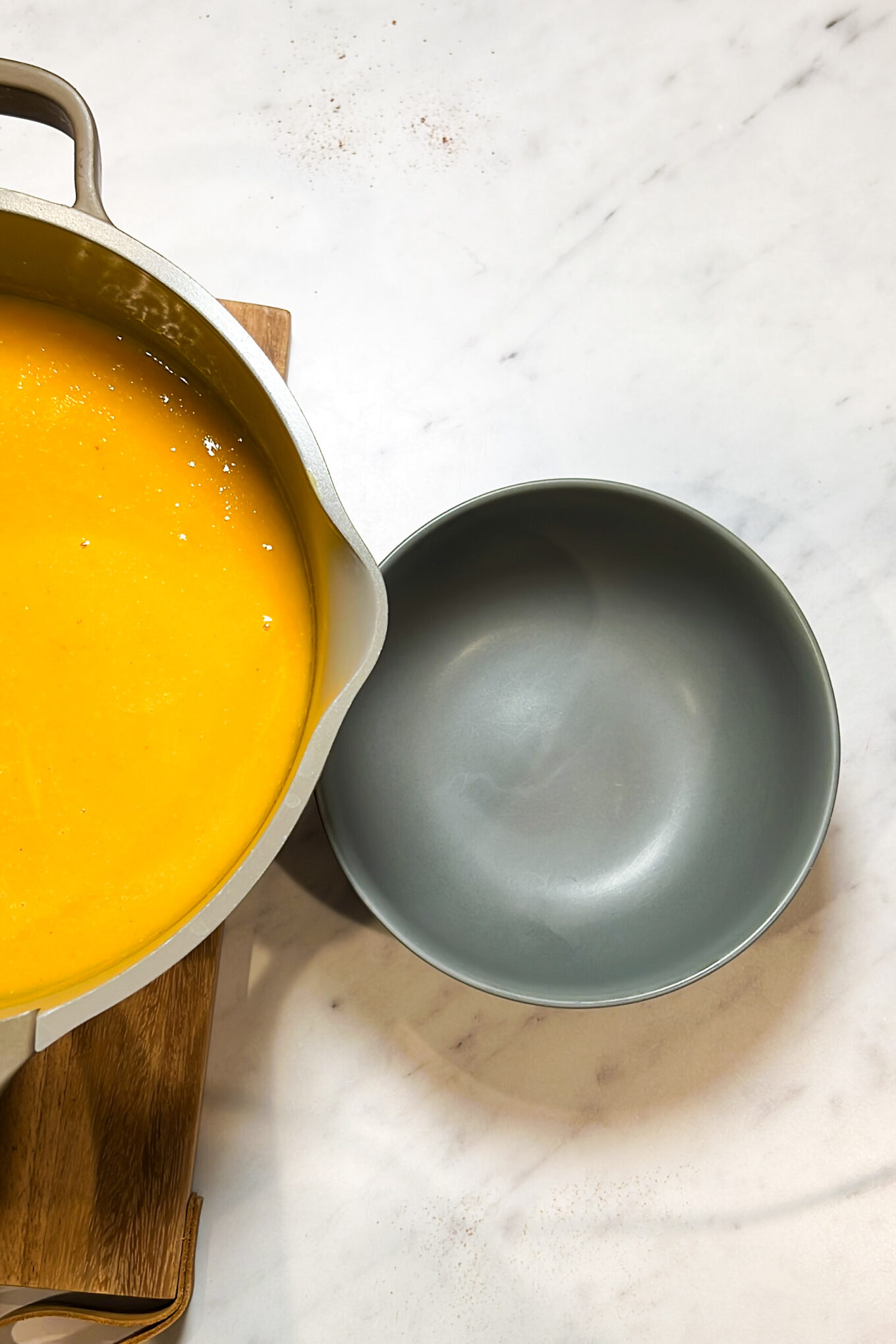 Un tazón saludable de sopa de calabaza Butternut con una cuchara en la parte superior, que es a la vez fácil de hacer y delicioso.
