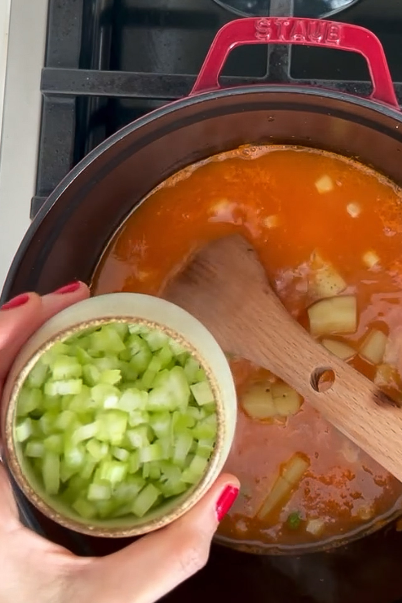 Una persona sostiene un cuenco de sopa sana con verduras.