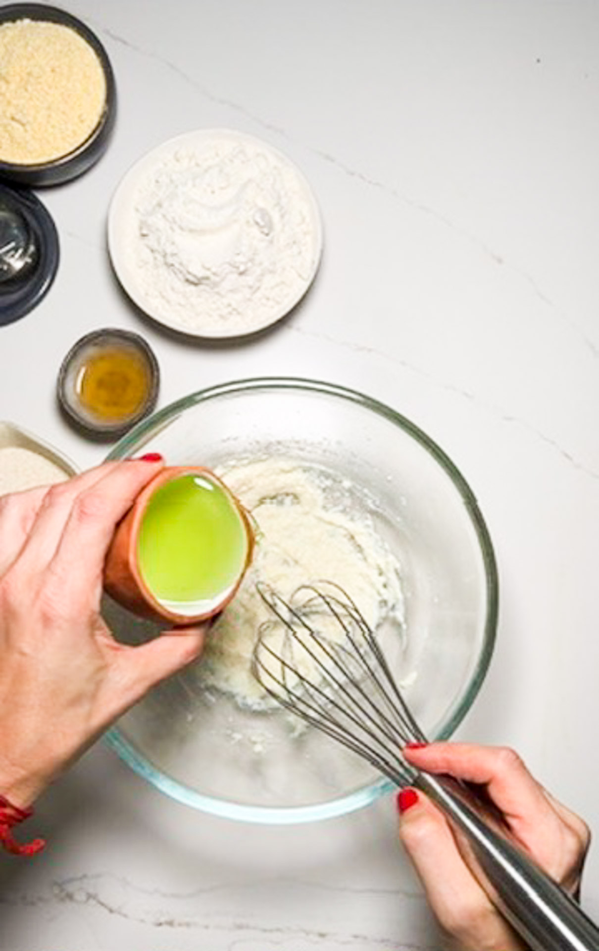 Una persona está mezclando ingredientes en un bol con un batidor para crear una receta vegana de pan de maíz.