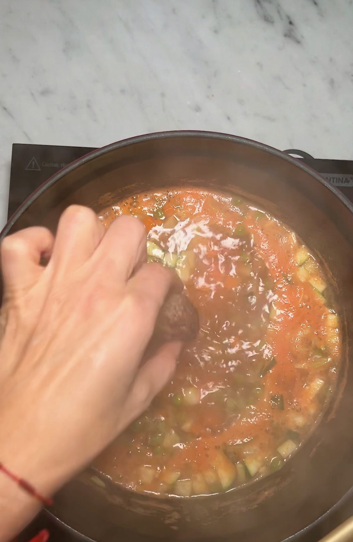 Una persona removiendo una olla de sopa vegana mexicana.