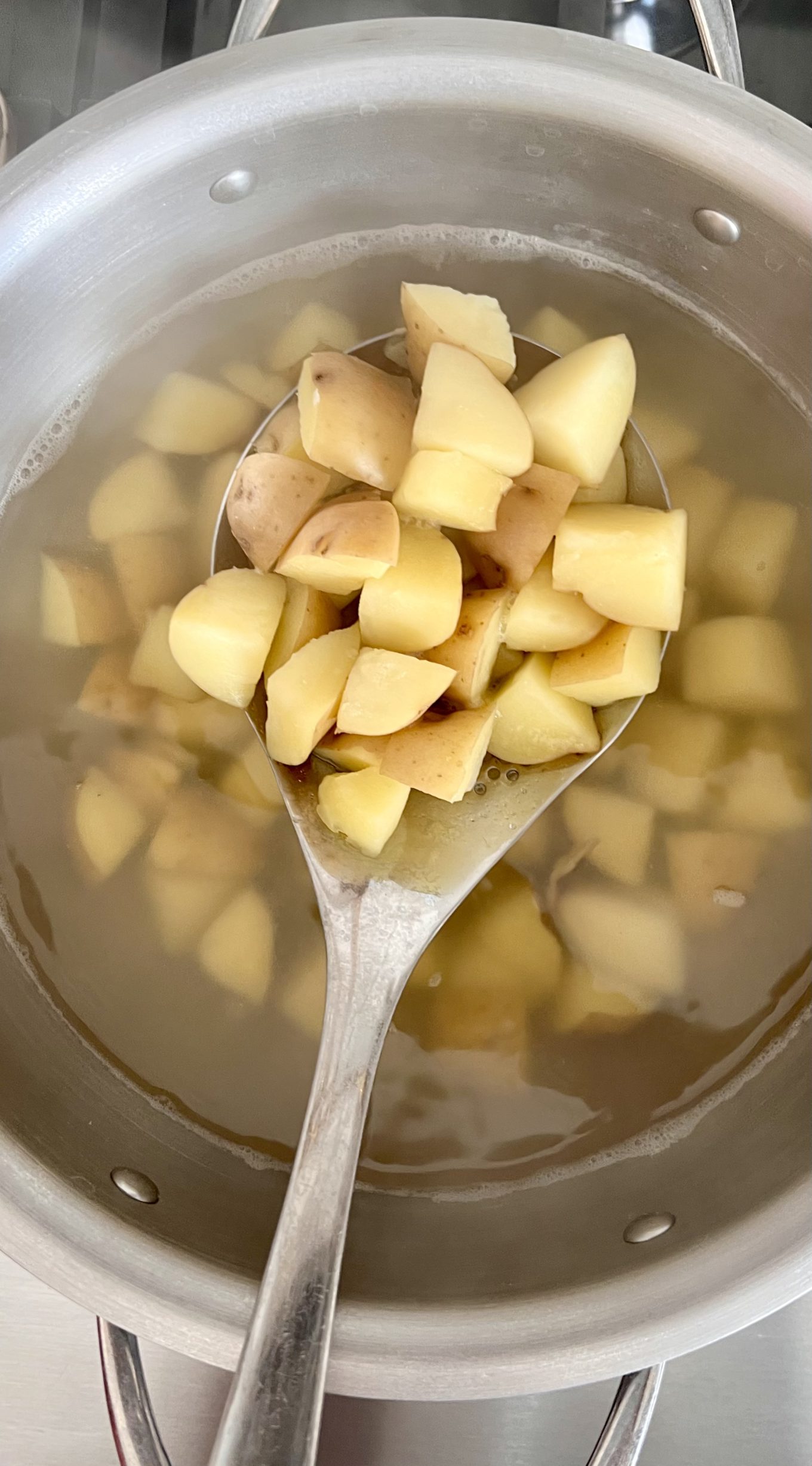 Una cuchara en una olla de sopa de papa macha.