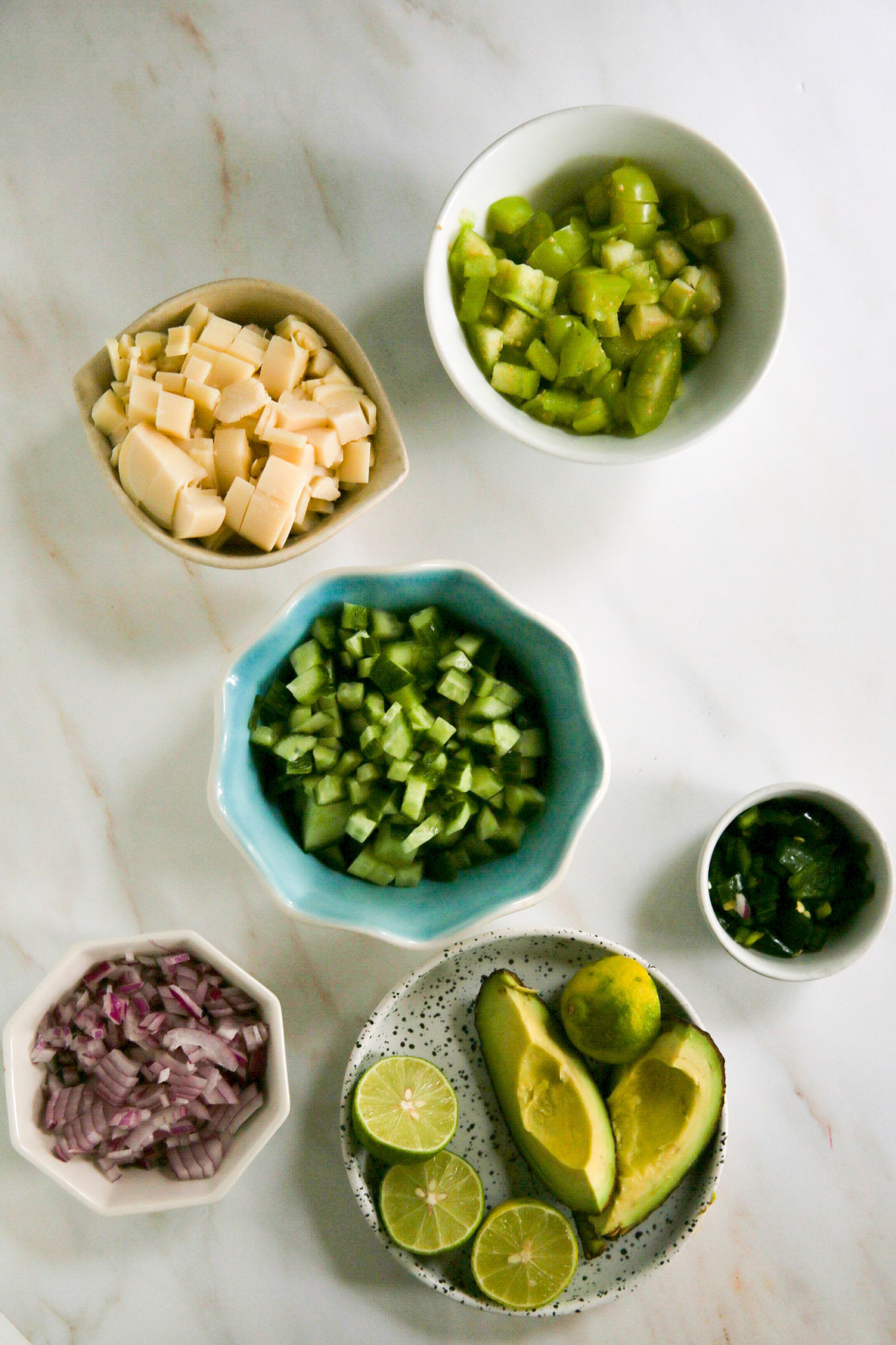 Los ingredientes del guacamole, incluidas las tostadas, están dispuestos sobre una mesa.