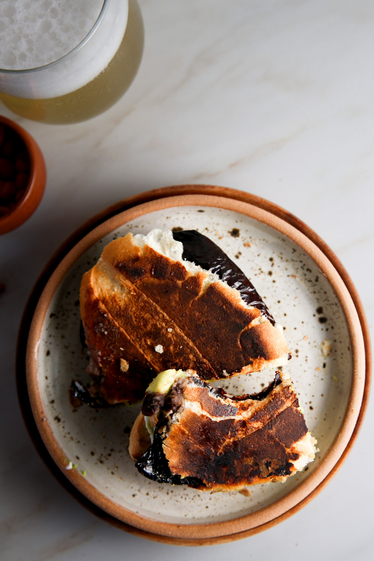 Unas Tortas de chile ancho en un plato junto a un vaso de cerveza, que muestra la cocina tradicional mexicana.