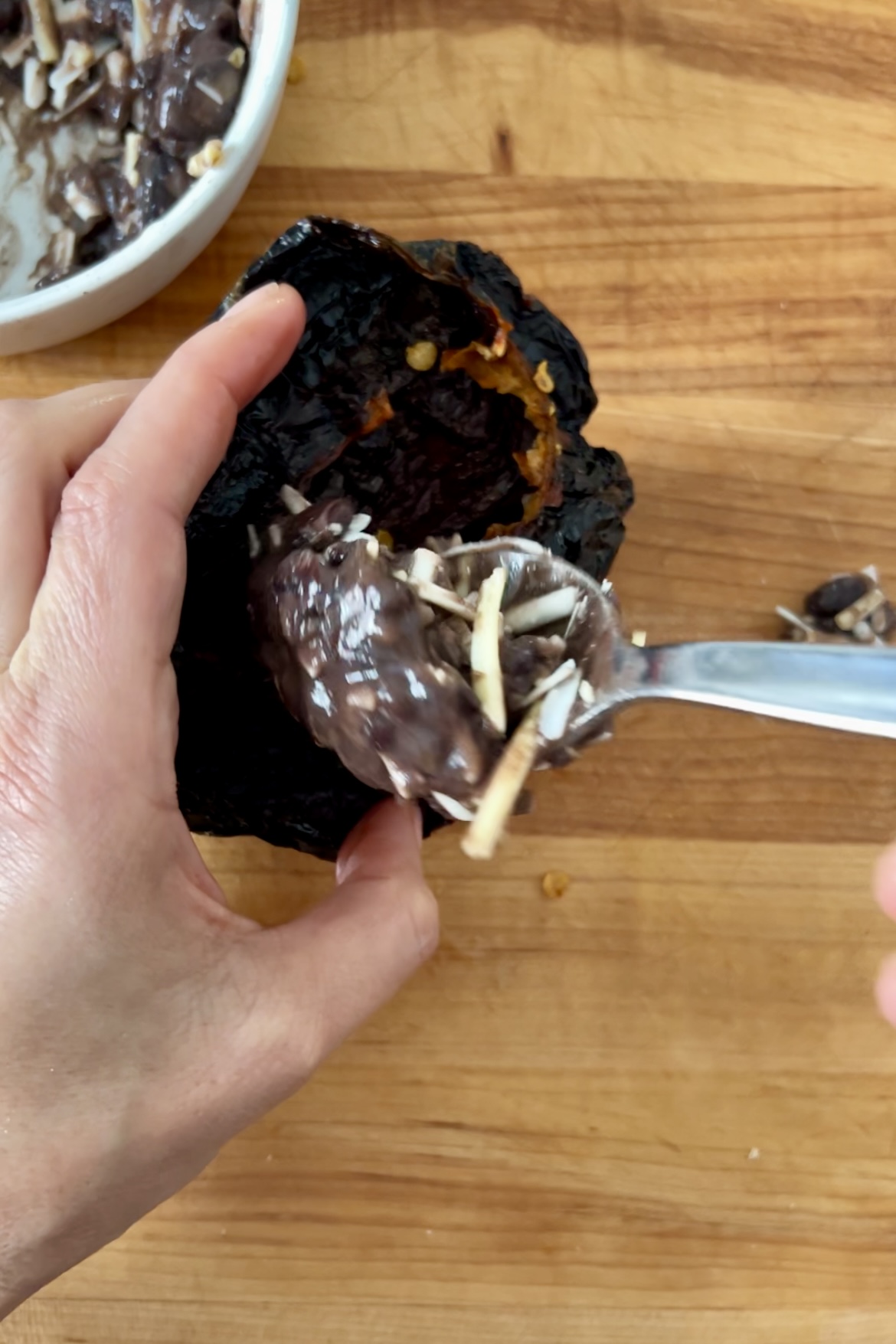 Una persona usando una cuchara para comer tortas de chile ancho cubiertas de chocolate.